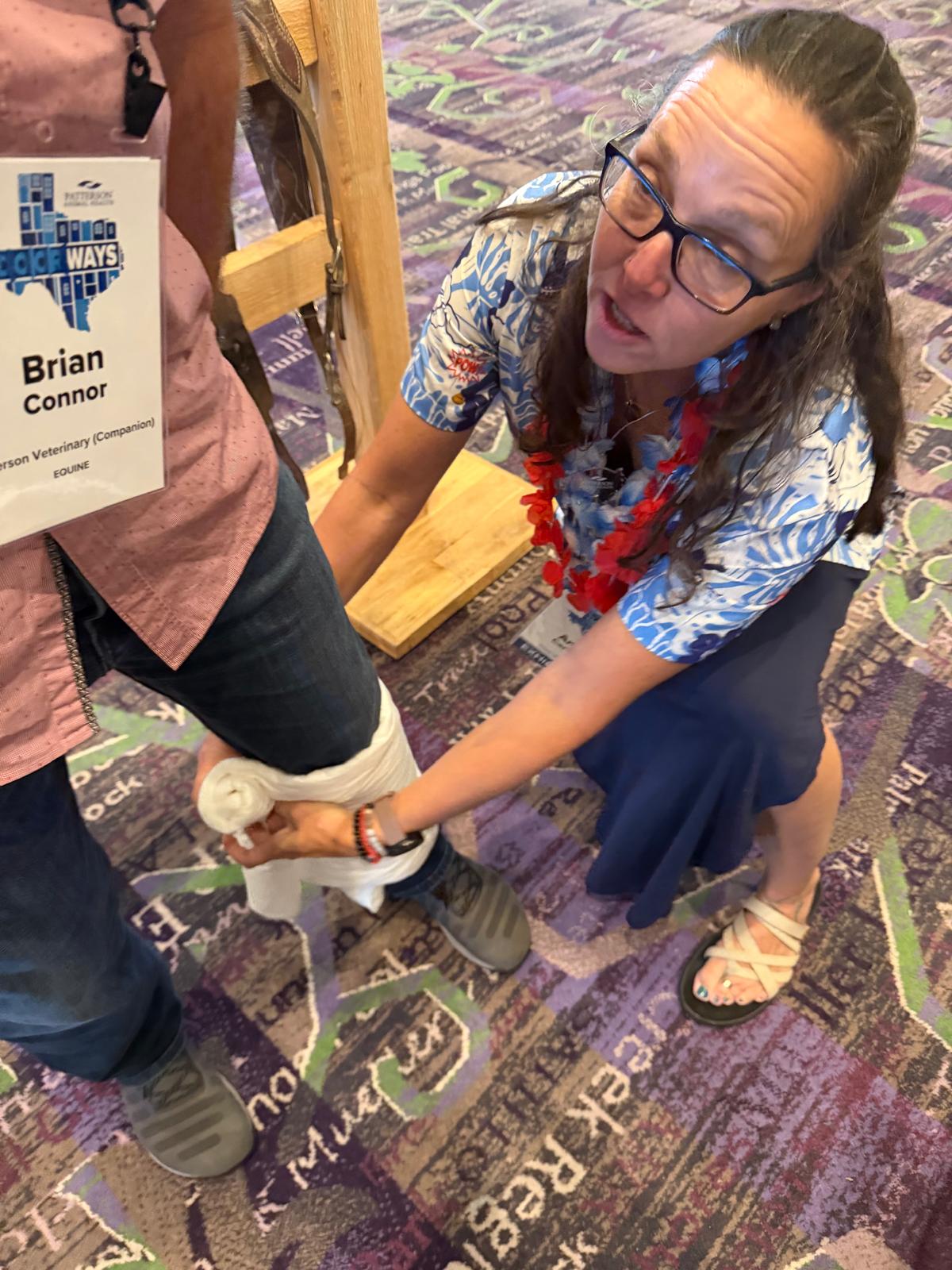 A VETSHARPE equine leg wrap being demonstrated on a colleague's lower leg at the conference